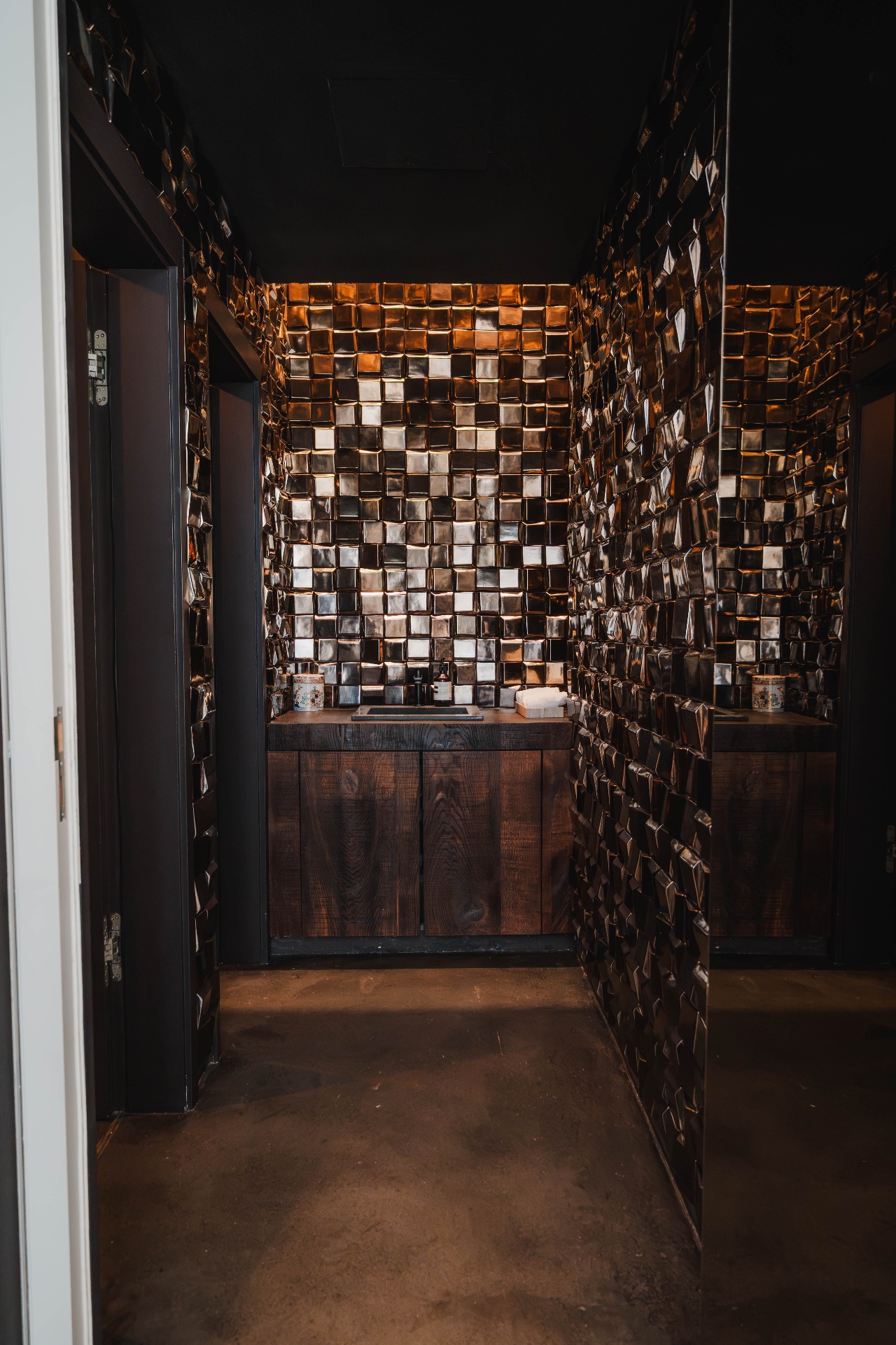 WC mit bronzefarbenen Metallfliesen und dunklem Holz